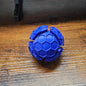Blue geometric ball on a wooden surface with clickers inside.