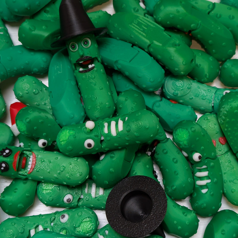 Collection of green toy pickle figures with various facial expressions on a white background